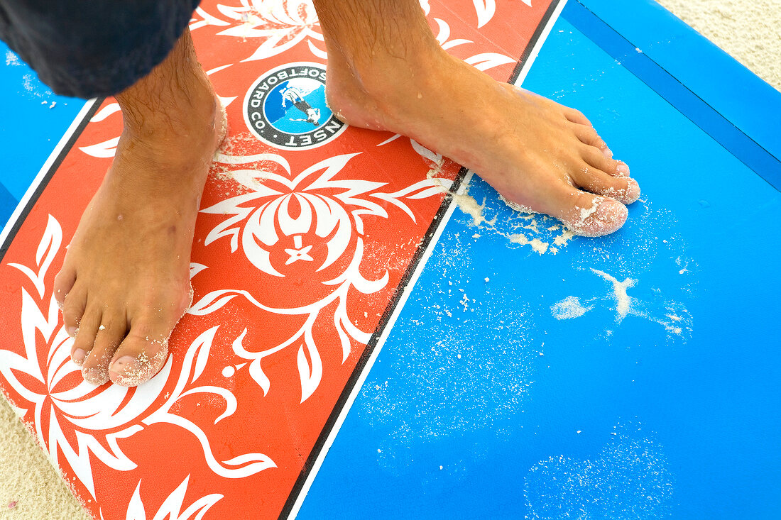 Close-up of man's feet on surfing board in Dhigufinolhu island, Maldives