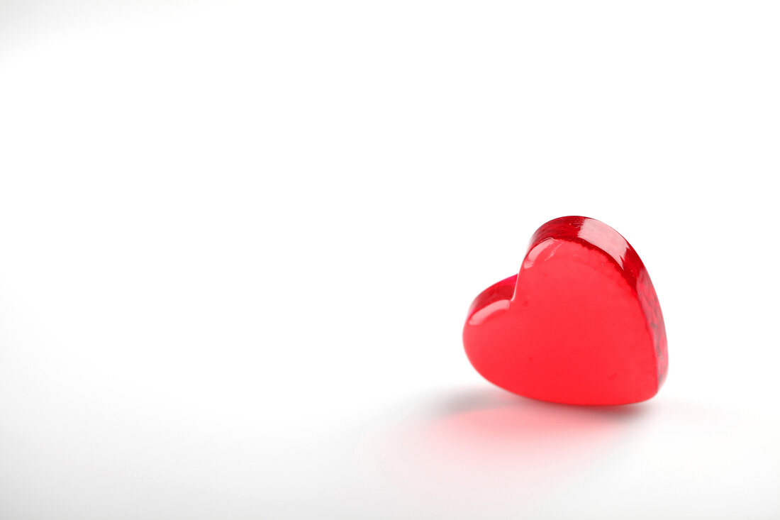 Red glass heart on white background