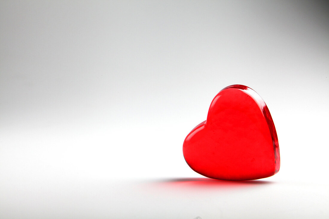 Red glass heart on white background