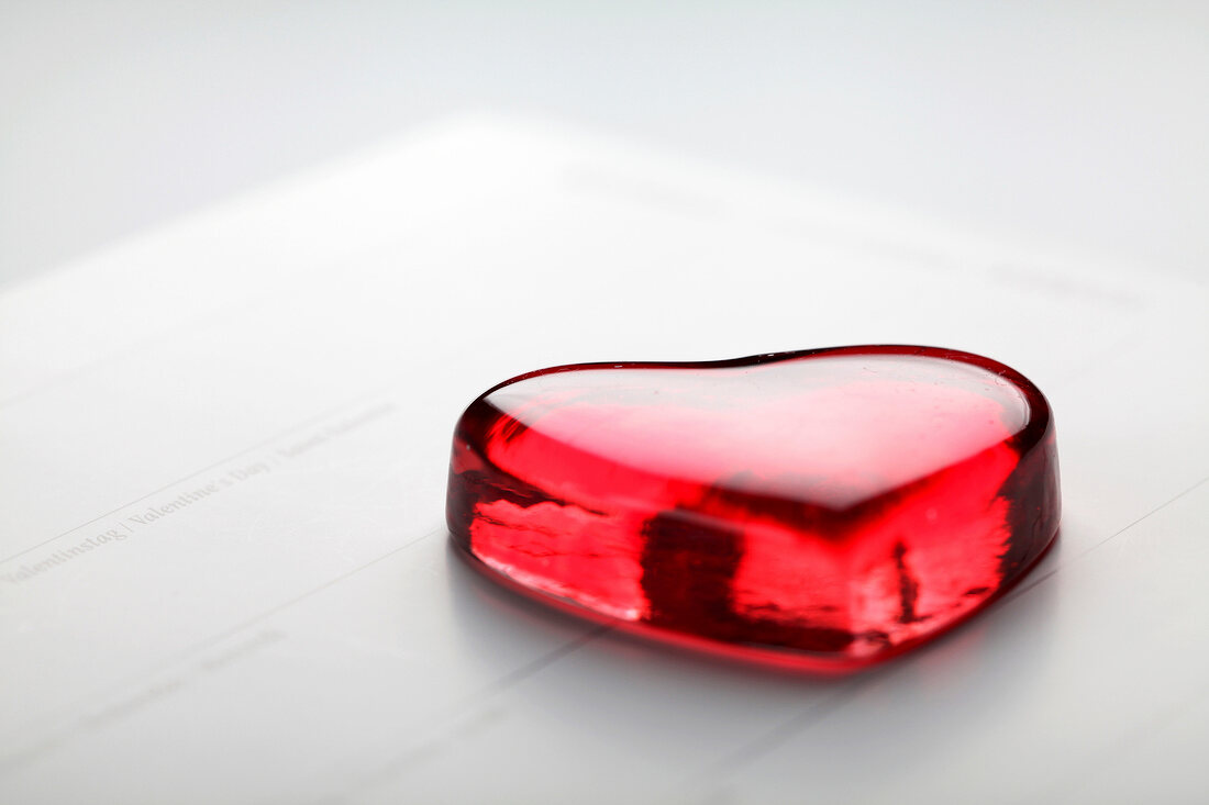 Red glass heart on white background