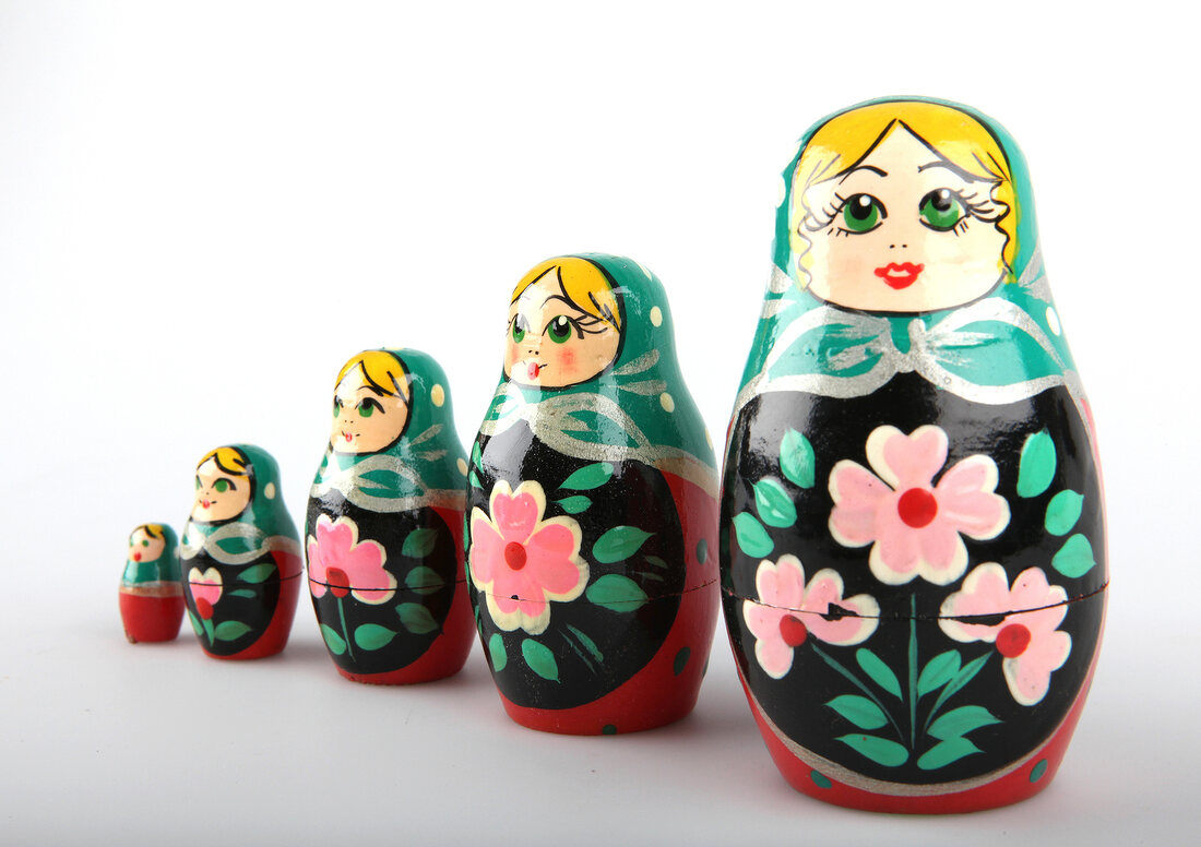 Five Russian dolls of various size on white background