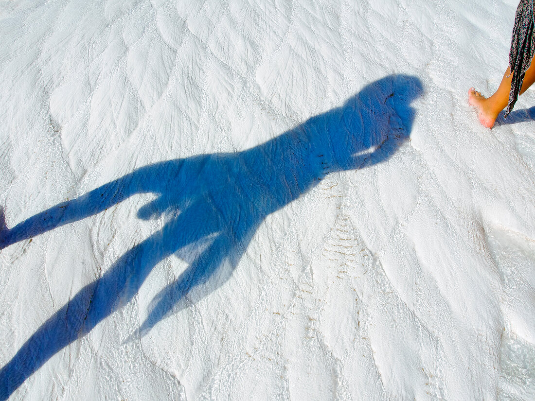 Shadow of woman on sand in Pamukkale, Aegean, Turkey