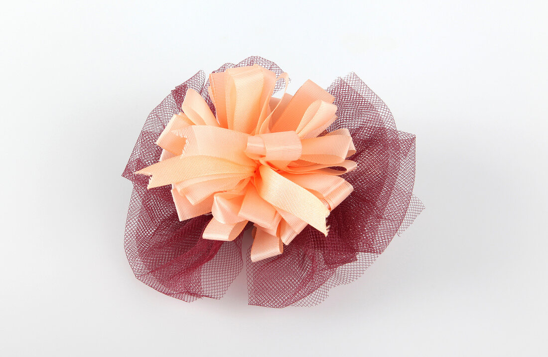 Loop made of burgundy coloured tulle on white background