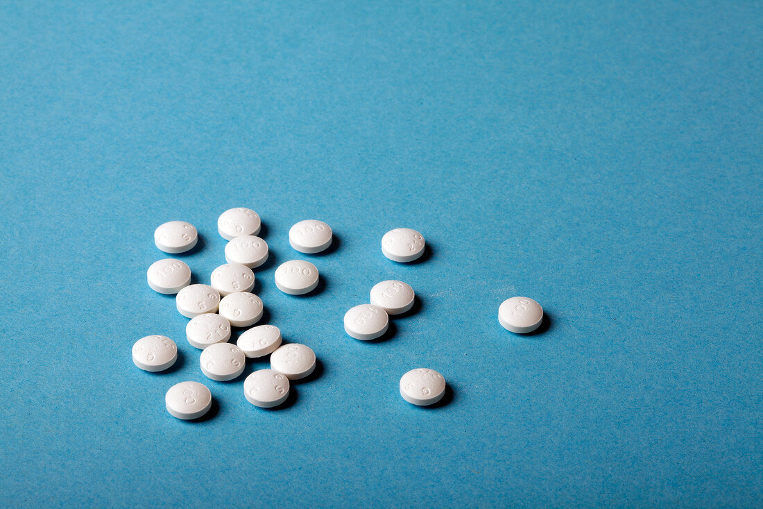 Close-up of white pills against blue background