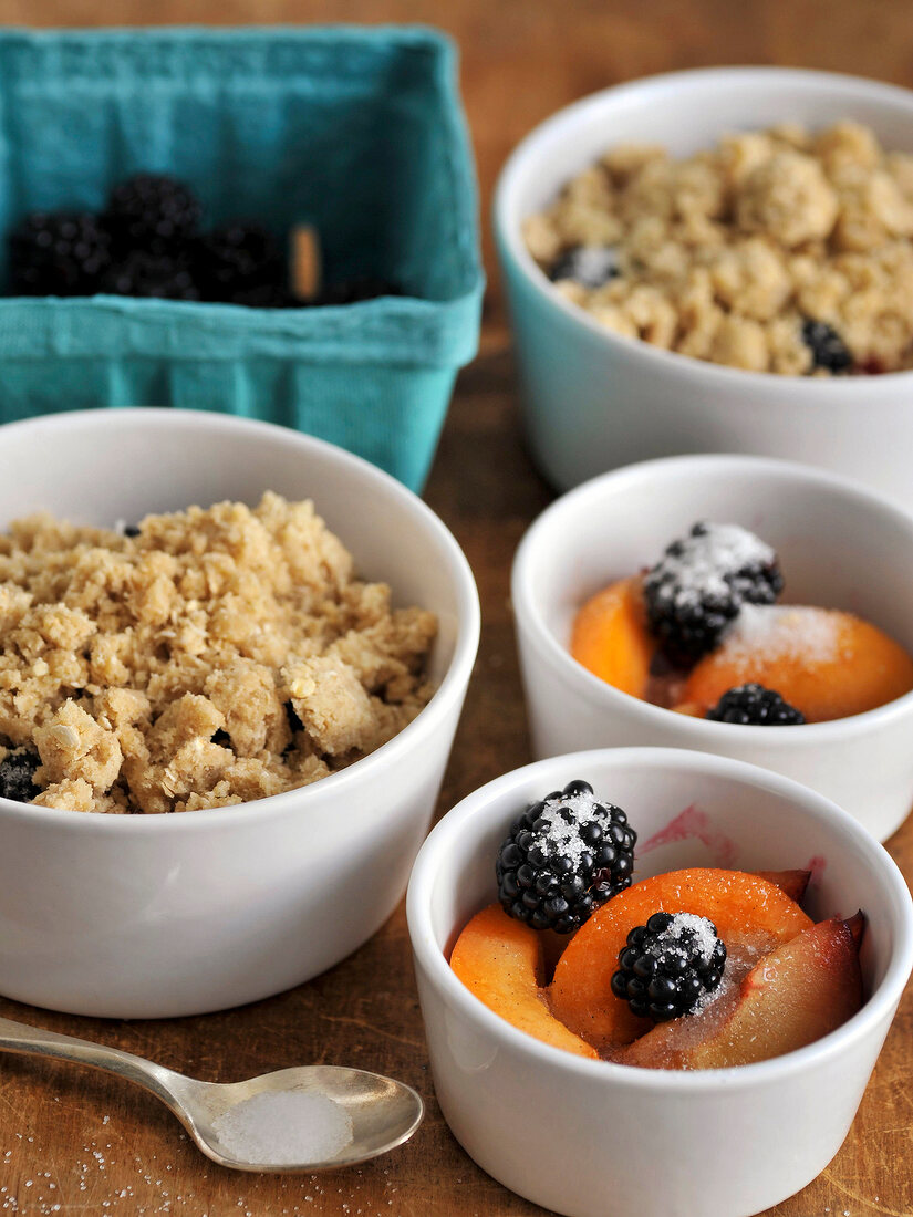 Crumble and fruits with sugar in bowls
