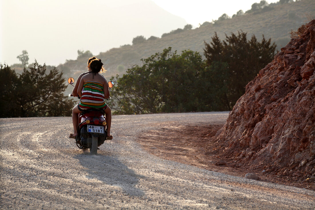 Rear view of tourists riding scooter on road, Resadiye Peninsula, Turkey