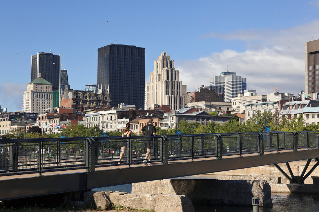 Joggers walking on bridge, overlooking city, Montreal, Canada