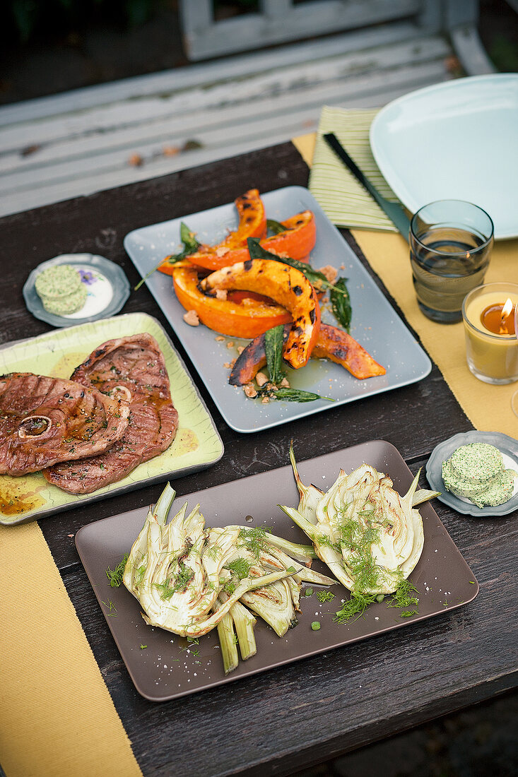 Lamb slices, grilled vegetables, pumpkin, fennel and herb butter on tray