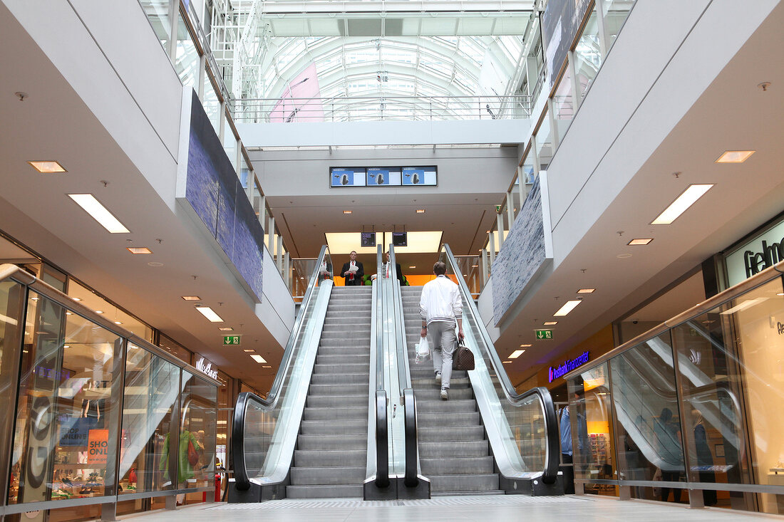 Rear view of man entering the escalator in department store