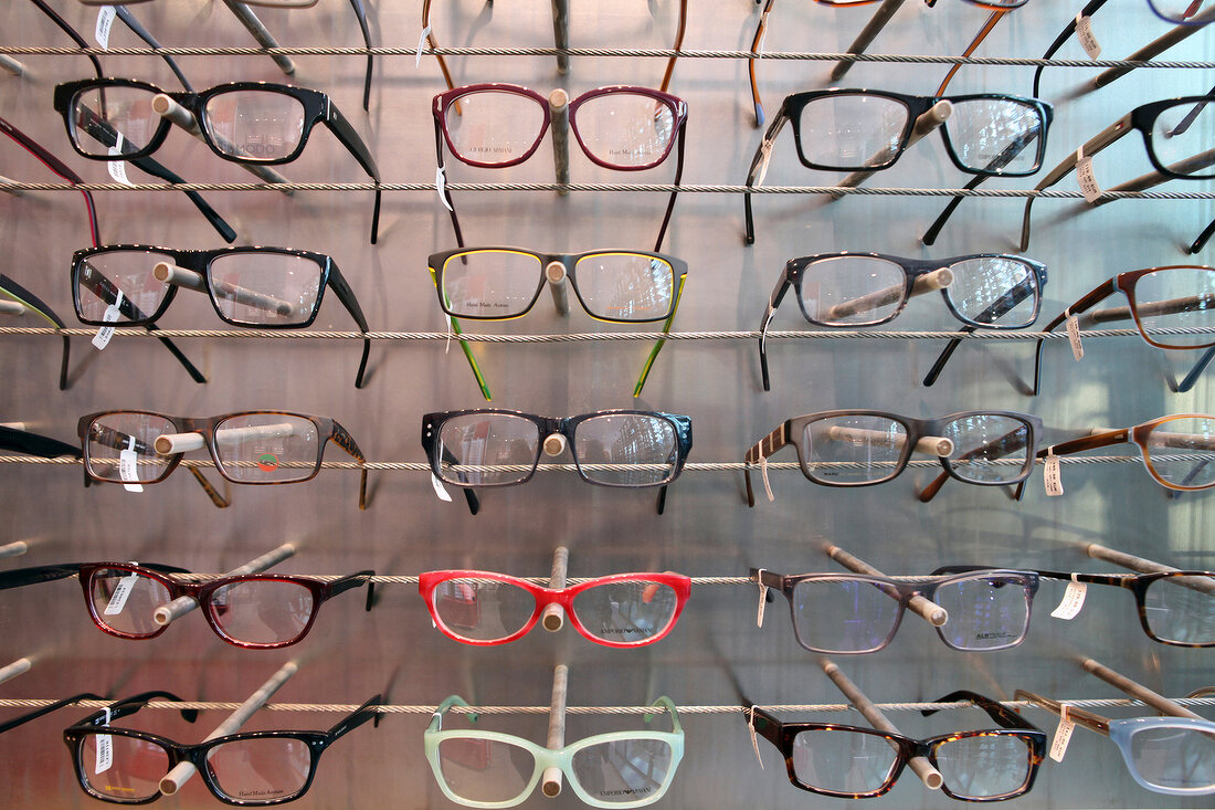 Glasses with colourful frames on shelf at optician