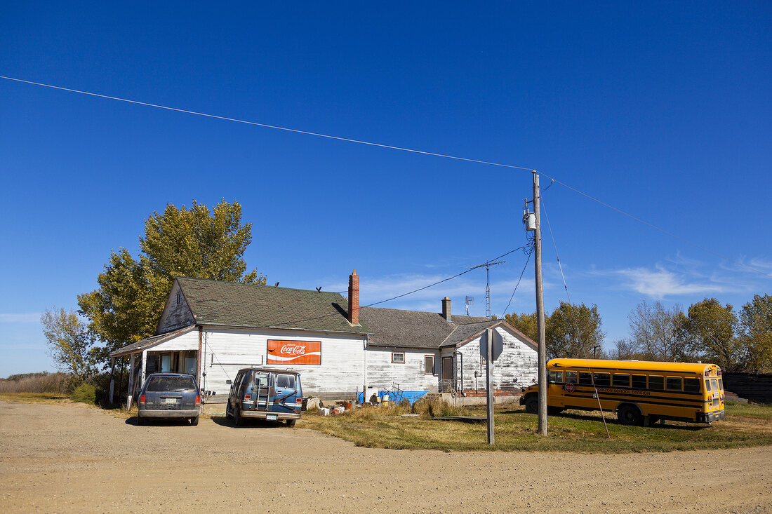 View of vehicles parked at house on Highway 20, Saskatchewan, Canada