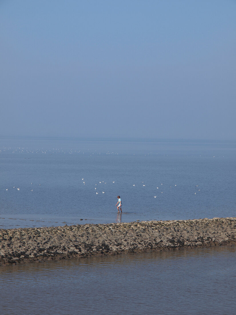 People standing near Wadden sea at Neuharlingersiel, Lower Saxony, Germany