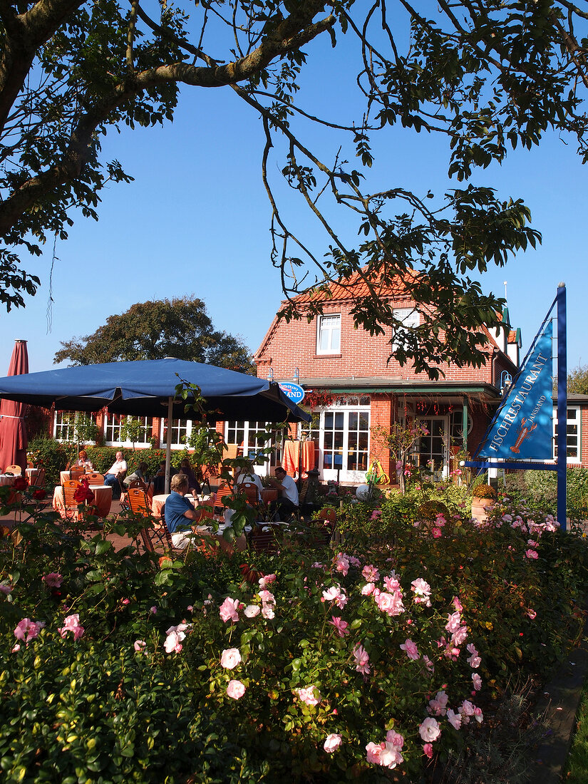 People sitting under shade at cozy restaurant at, Spiekeroog, Lower Saxony, Germany