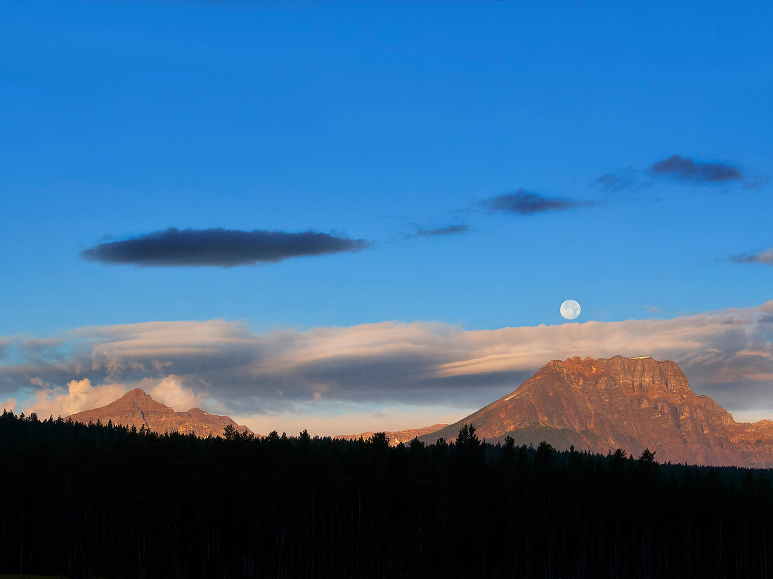 View of highway, blue sky and full moon in Banff National Park, Alberta, Canada