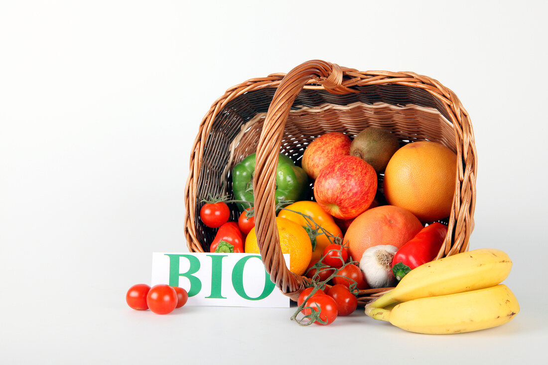 Basket of fruit and vegetables on white background