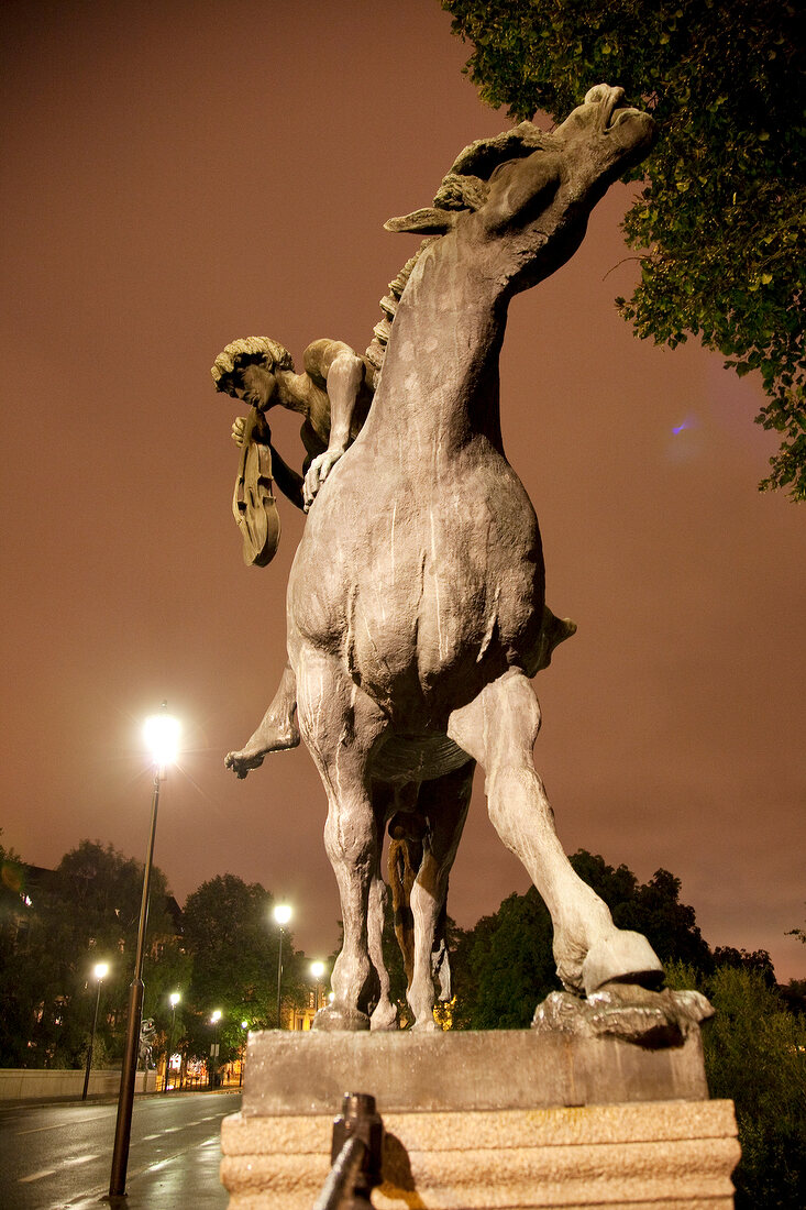 Statue of horse with horse rider holding violin near road in Oslo, Norway
