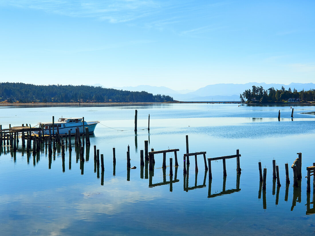 Moored boat floating on water with wooden pole at Vancouver Island, Oslo, Norway