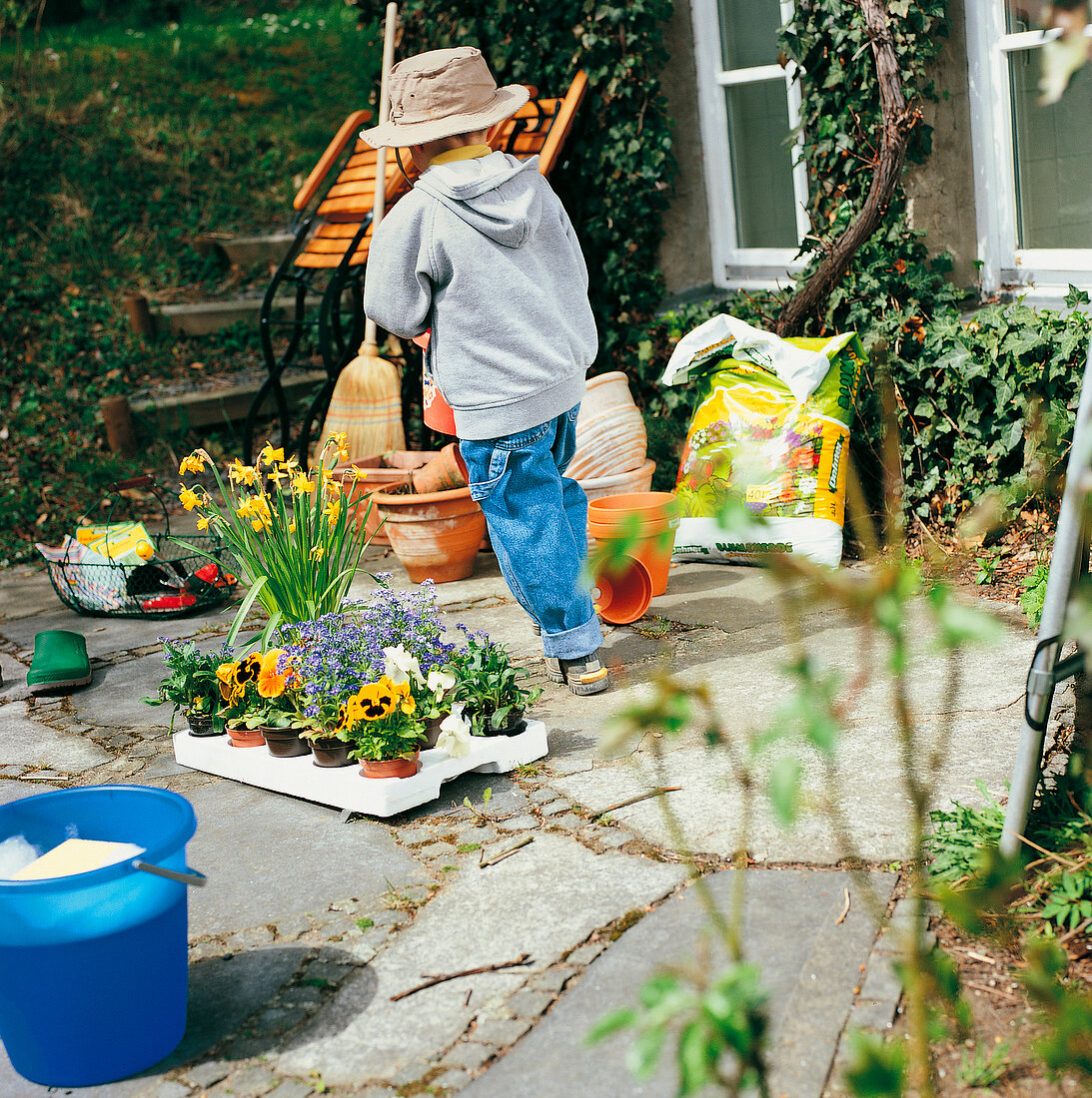 Weekend Gärtner, kleiner Junge auf Terrasse im Garten, spielt