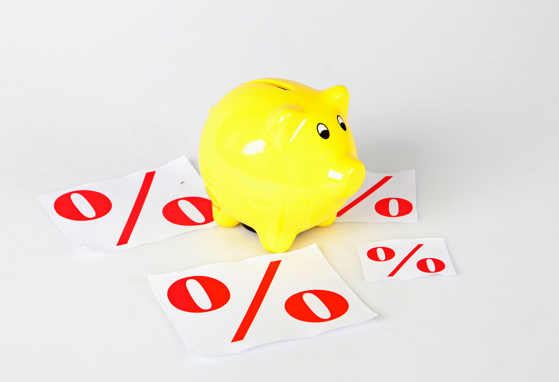 Close-up of yellow piggy bank with percentage sign symbolizing discount