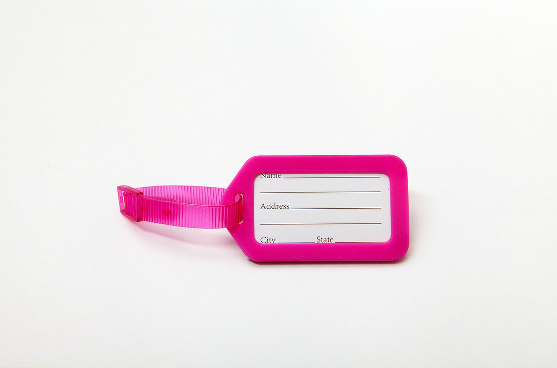 Close-up of pink luggage tag on white background
