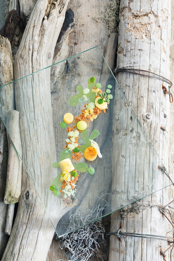 Plate of white chocolate, cucumber sauce and buttermilk on wood