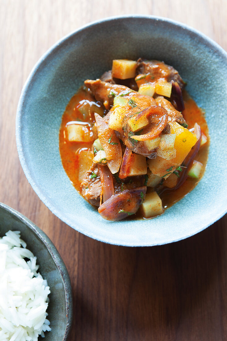 Red duck curry with pumpkin and apricot in bowl