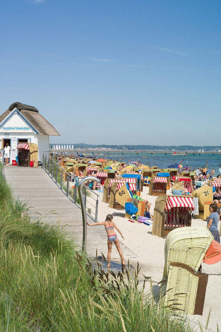 Hooded beach chairs and people on beach in Scharbeutz, Schleswig Holstein, Germany