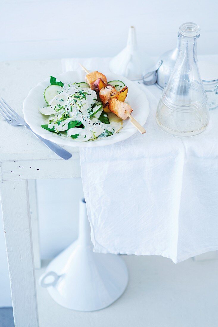 Vegetable salad with cucumber, kohlrabi, radish and salmon kebabs