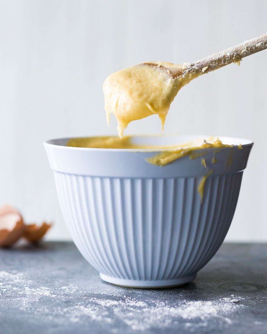 Cake mix in a bowl and on a wooden spoon