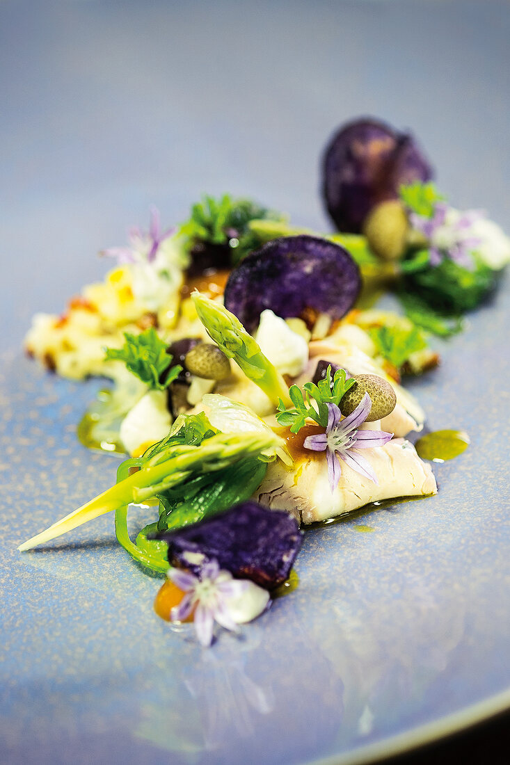 Close-up of Greek salad with veal, asparagus and garlic grass on plate