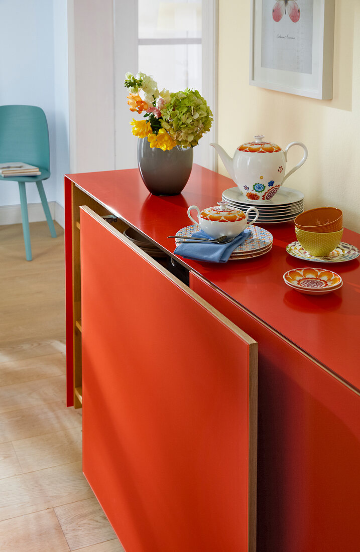 Sideboard in orange mit Schiebetüren, Geschirr, Deko