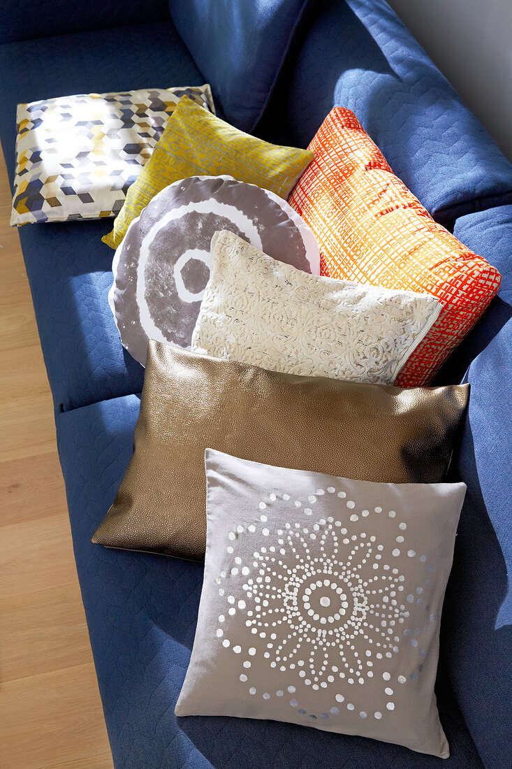 Blue sofa with various patterned pillows