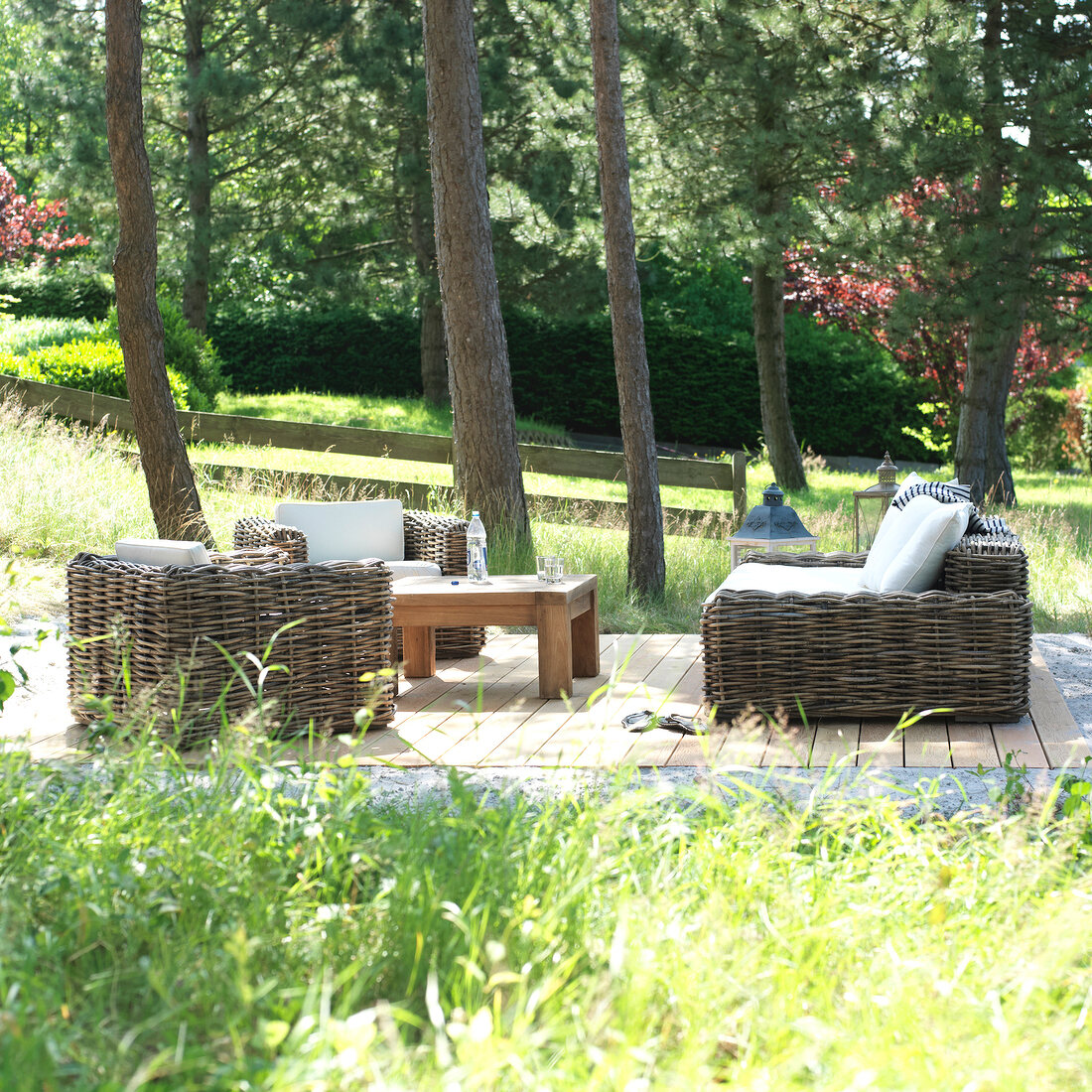 View of garden with wooden chair, cushions and table