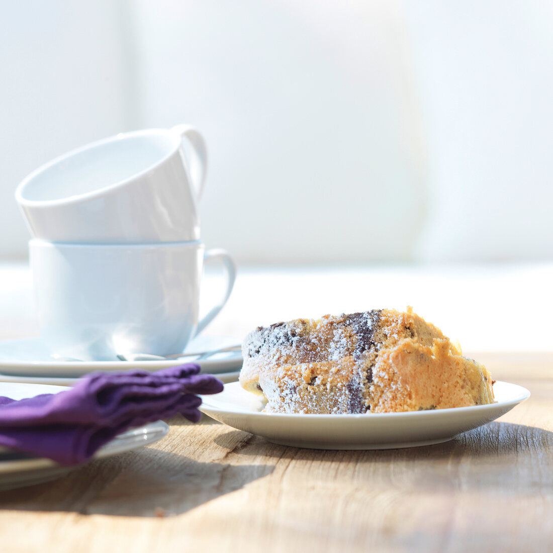 Piece of cake and coffee cups on table