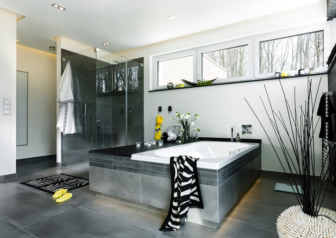 Luxury style bathroom with bathtub, resting bench, shower cubicle in anthracite tone