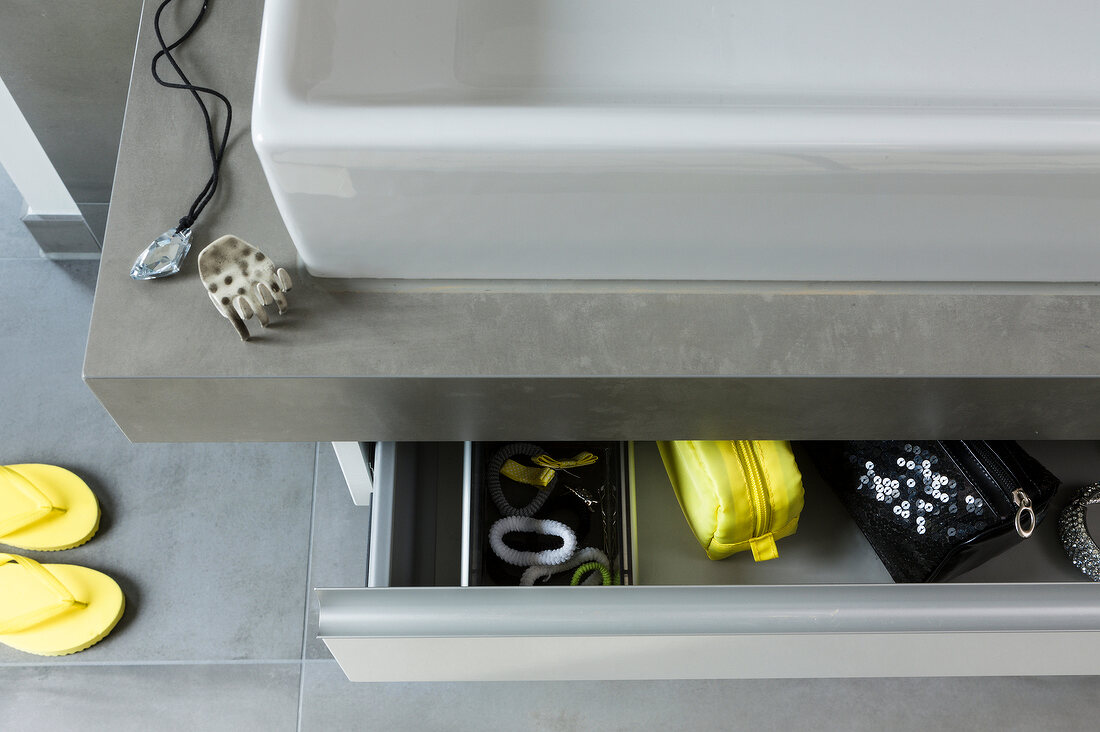 Close-up of drawer in sink cabinet with accessories