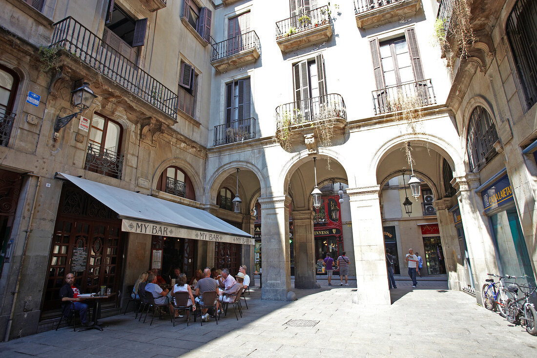 Tourist at Placa Reial alley near sidewalk cafe in Barcelona, Spain