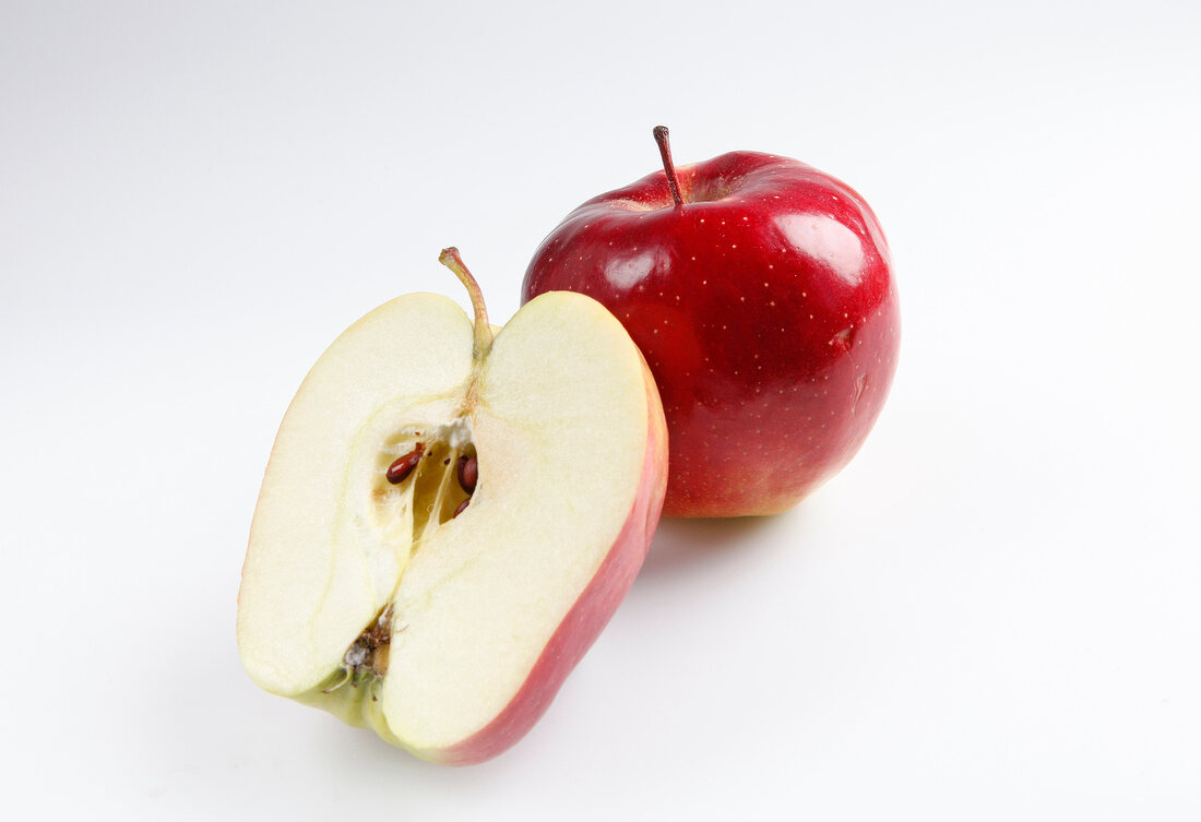 Whole and halved apple on white background