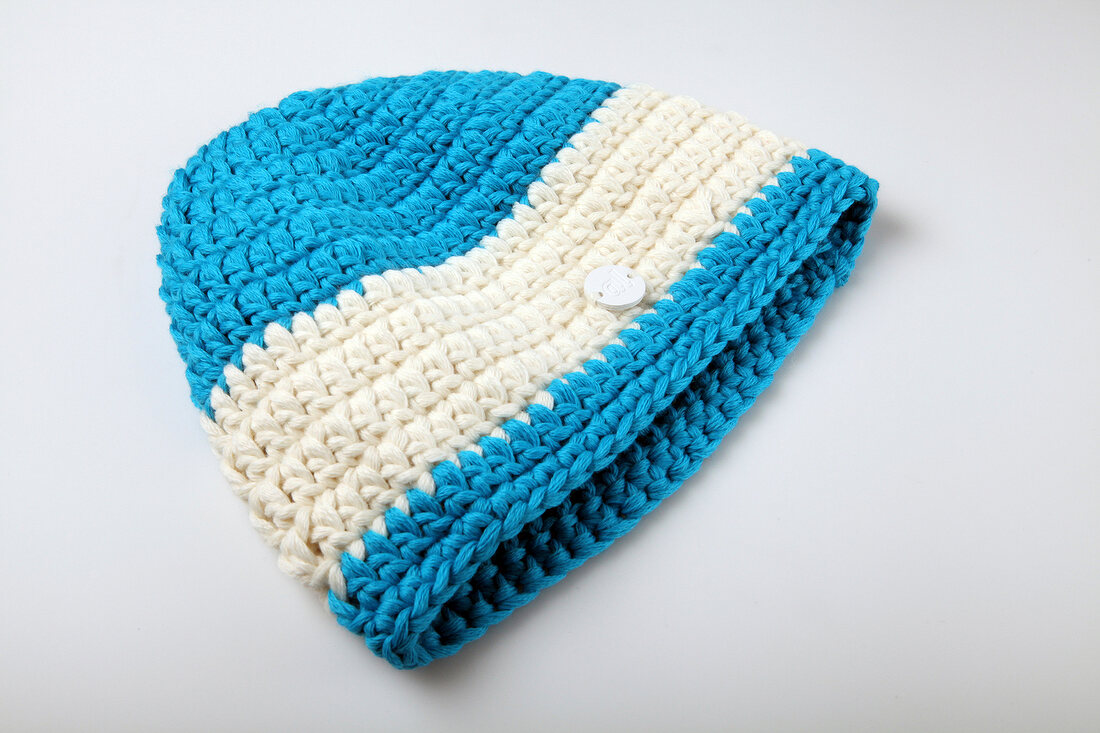 Close-up of blue and white woolen knitted hat on white background