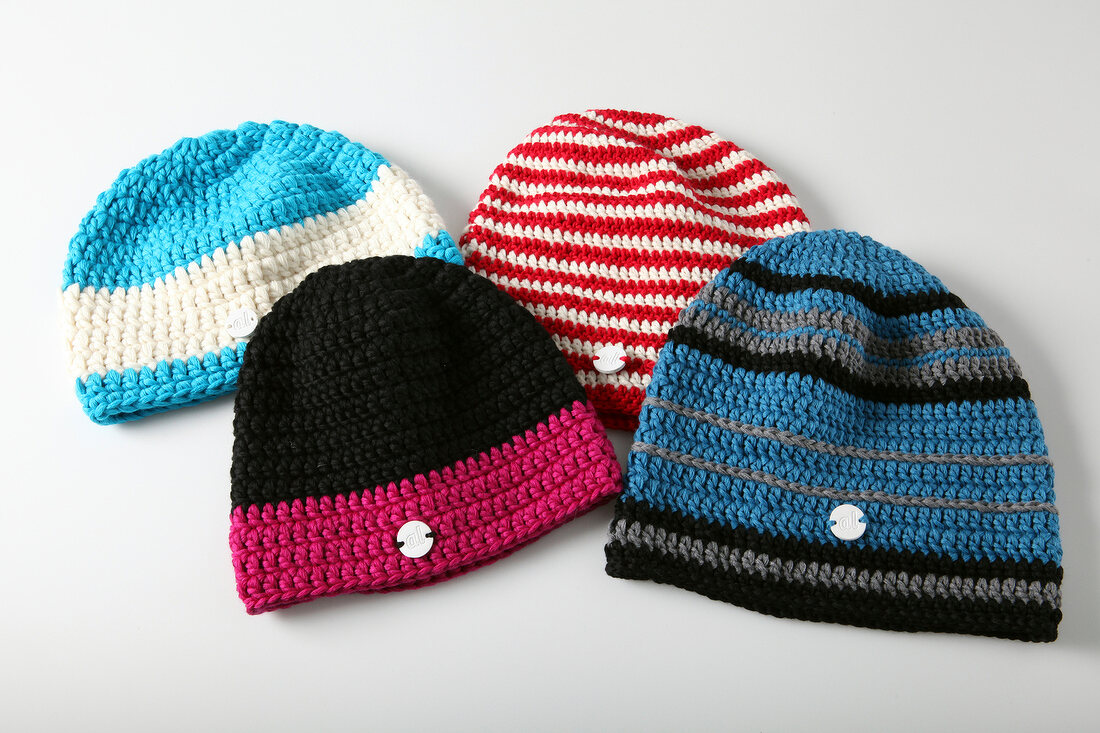 Four colourful knitted hats on white background