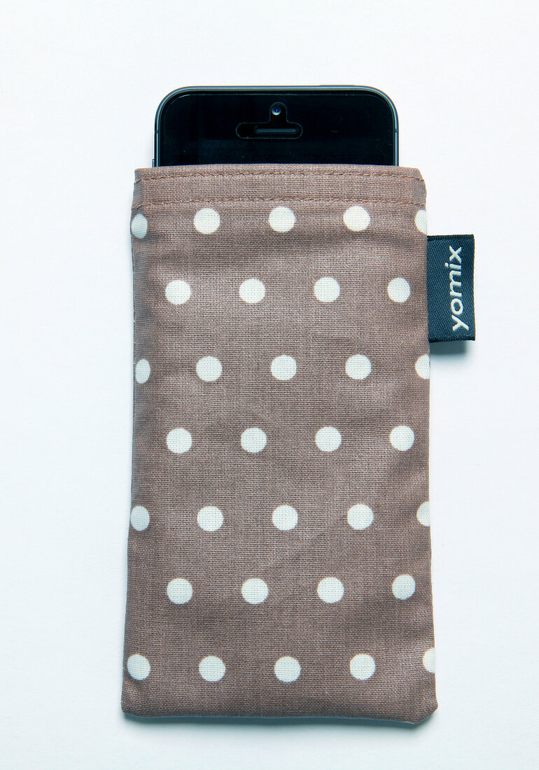 Close-up of gray mobile phone case with white dots on white background