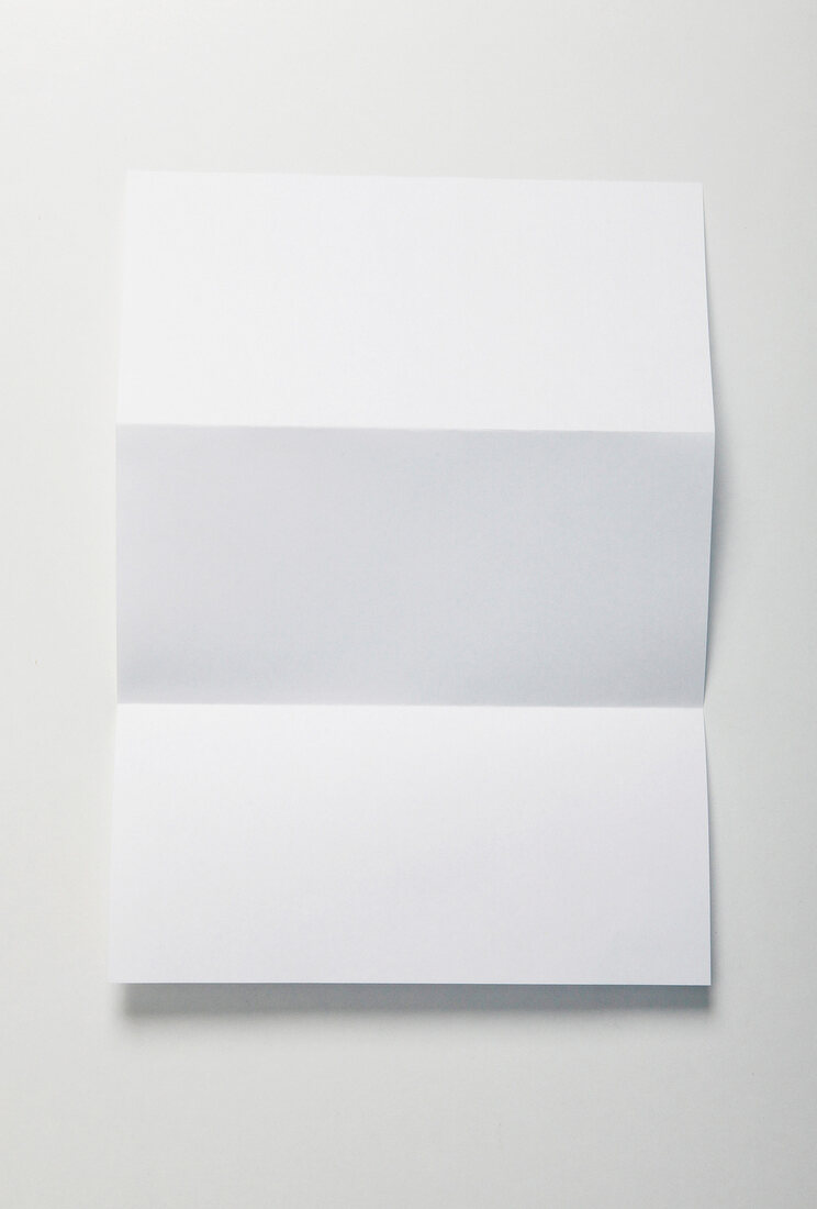 Close-up of sheet of folded paper on white background