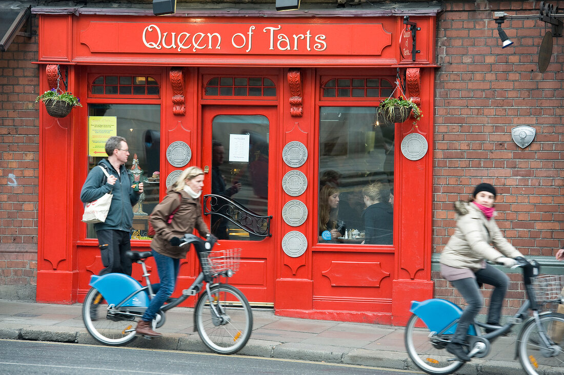 Cyclists on street in front of Queen Of Tart bakery at Dublin, Ireland