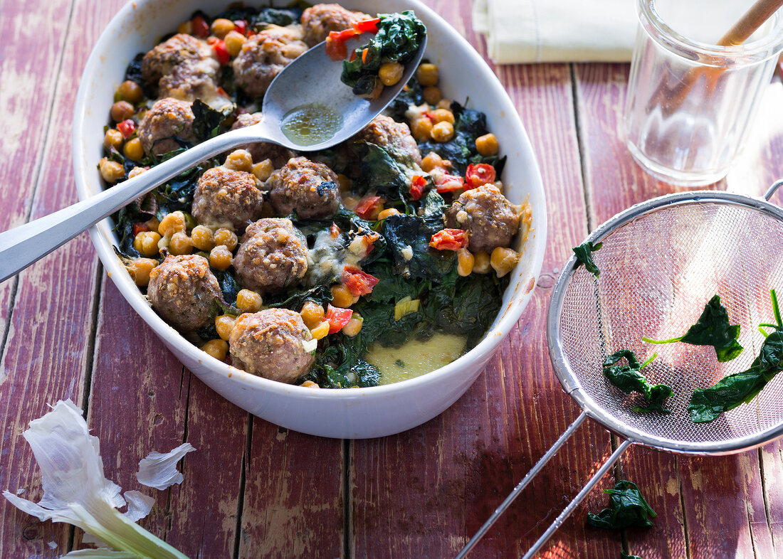 Spinach gratin with meatballs in bowl