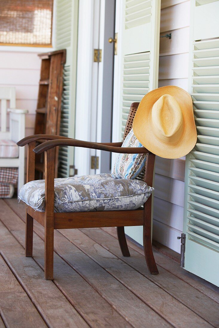 Wooden armchair with seat cushion on veranda