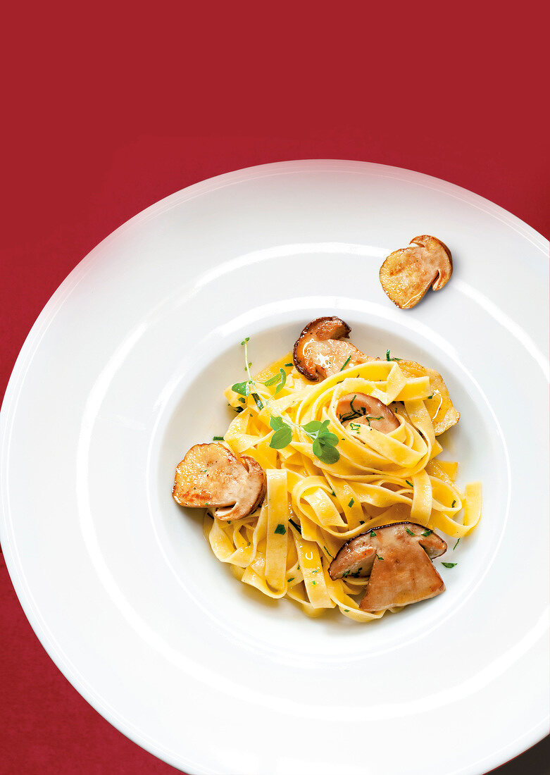 Close-up of fettuccine pasta with mushrooms on plate