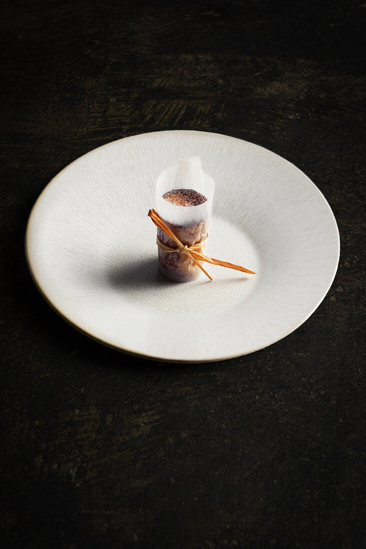 Apple pie with perfumed rice milk, wrapped in paper on plate