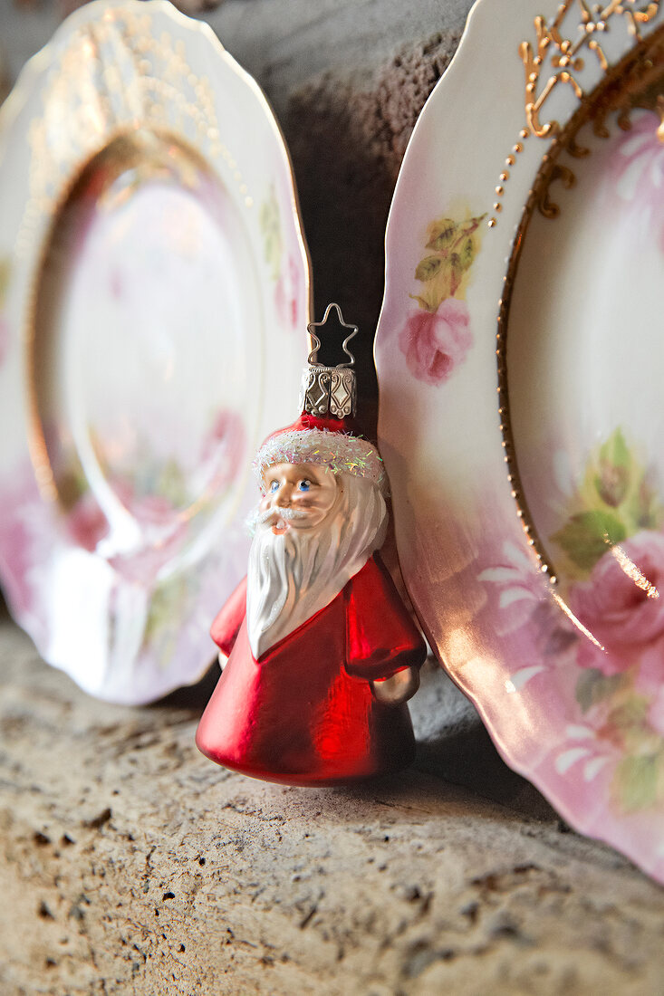 Close-up of Santa Clause figurine between plates