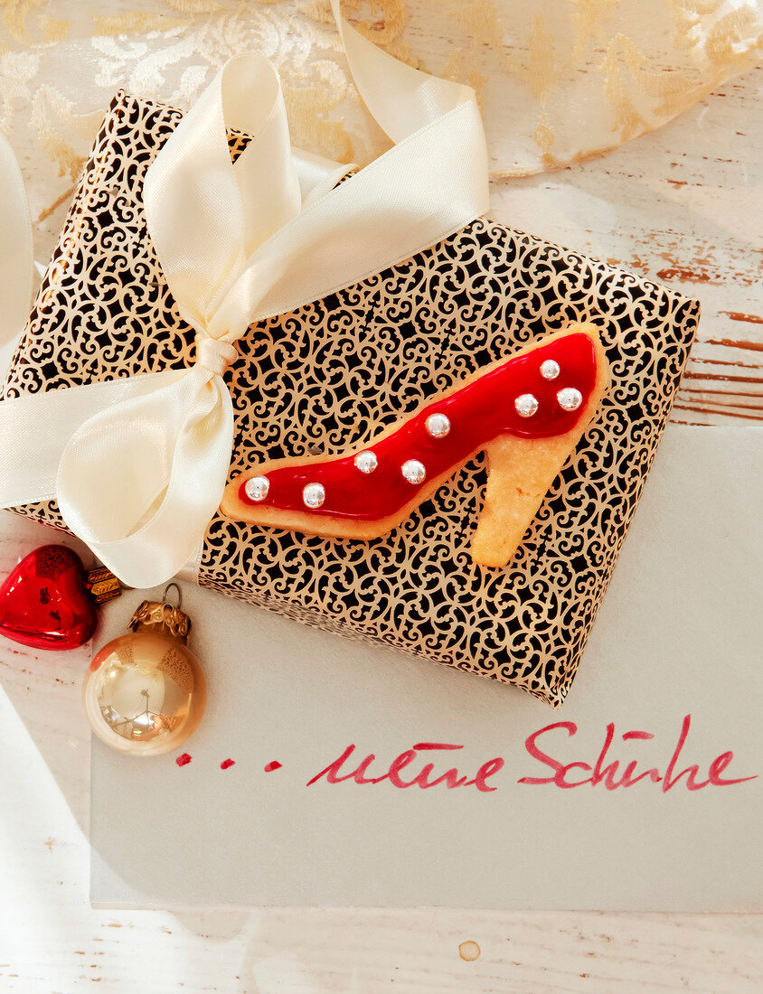 Close-up of shoe shaped biscuit on gift with white ribbon