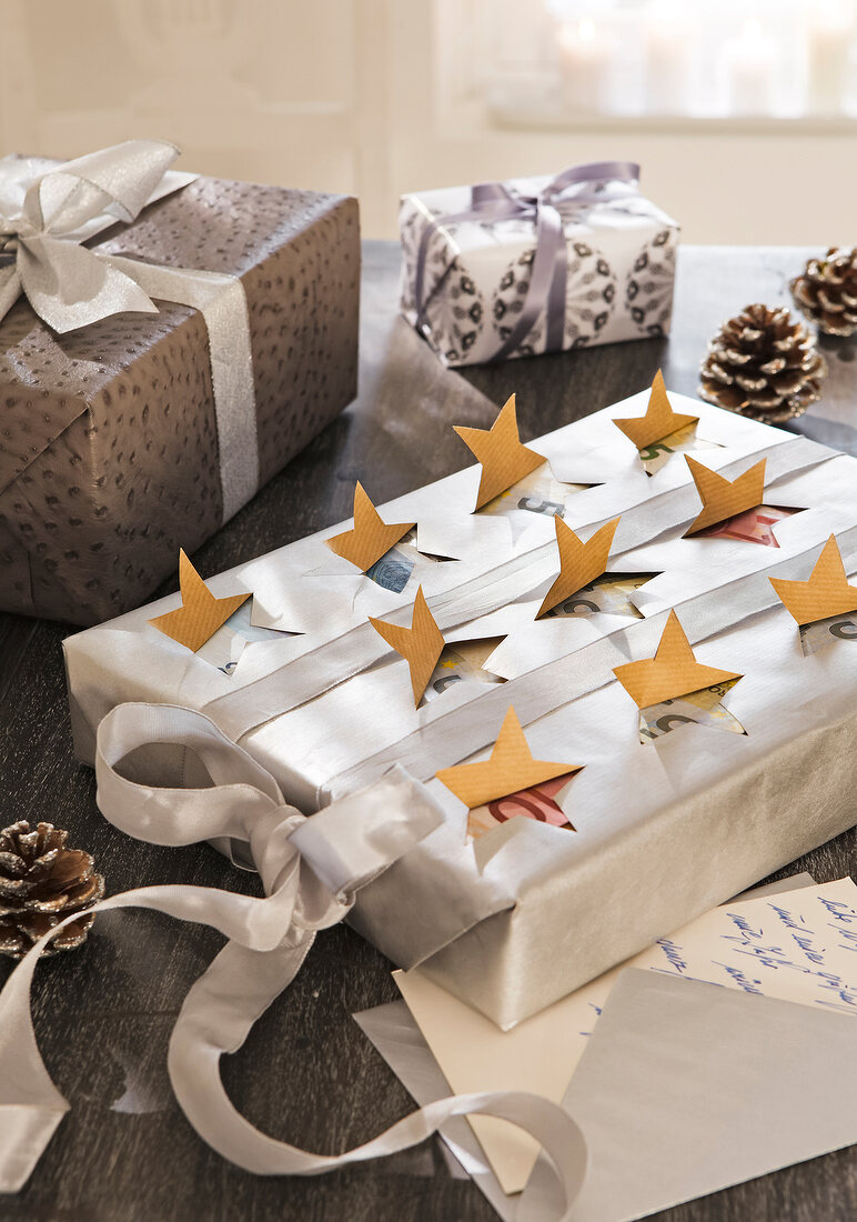 Close-up of gift wrap decorated with ribbons and stars with several gifts